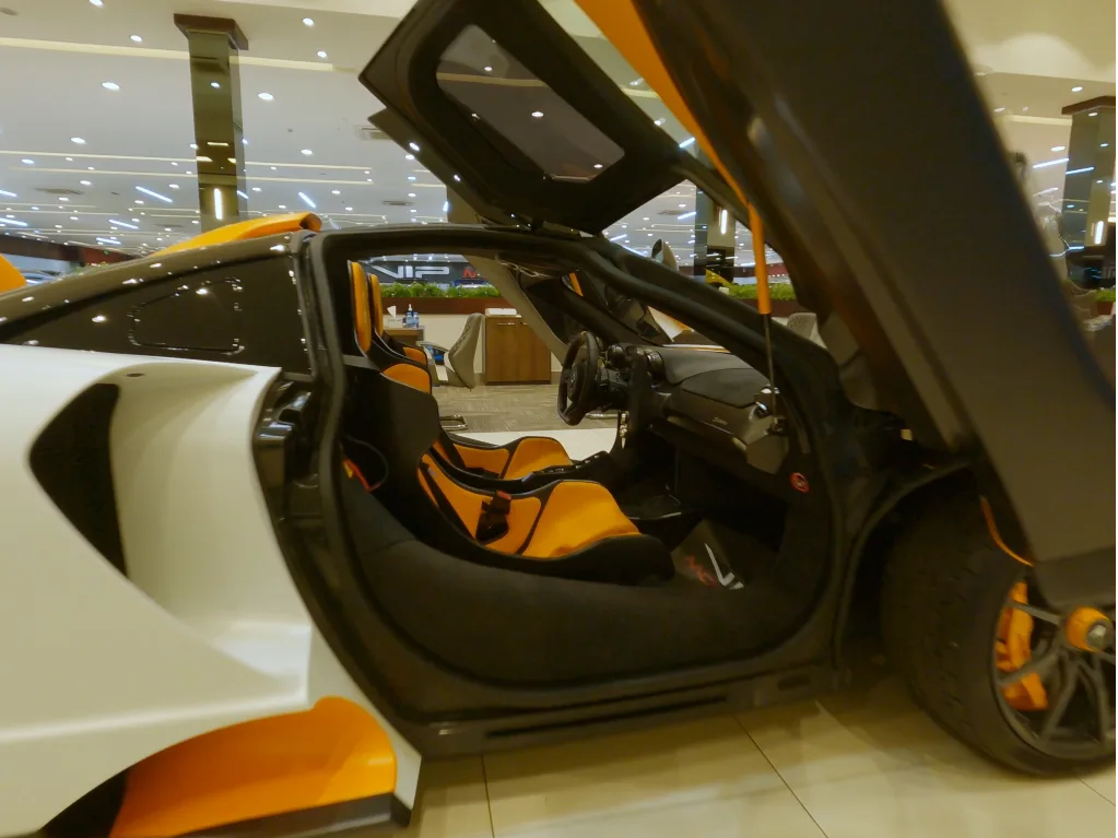 Indoor FPV cinewhoop drone flying inside a super car